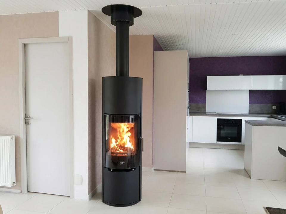 Salon moderne avec insert à bois encastré dans un habillage en pierre naturelle schisteuse gris anthracite, couvrant toute la hauteur du mur